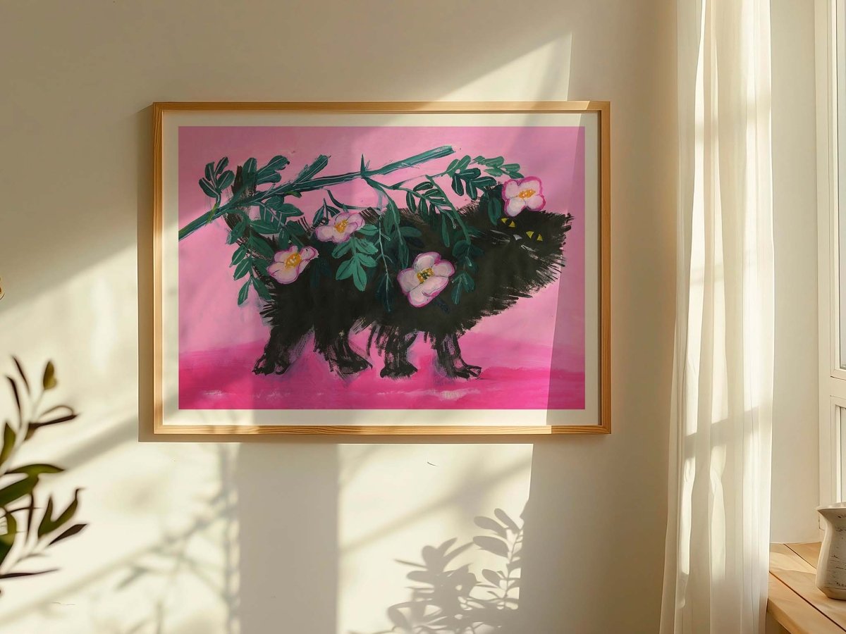 Thomas Winding plakat Pimme under roserne – dekorativ katteplakat udstillet i lyst interiør.