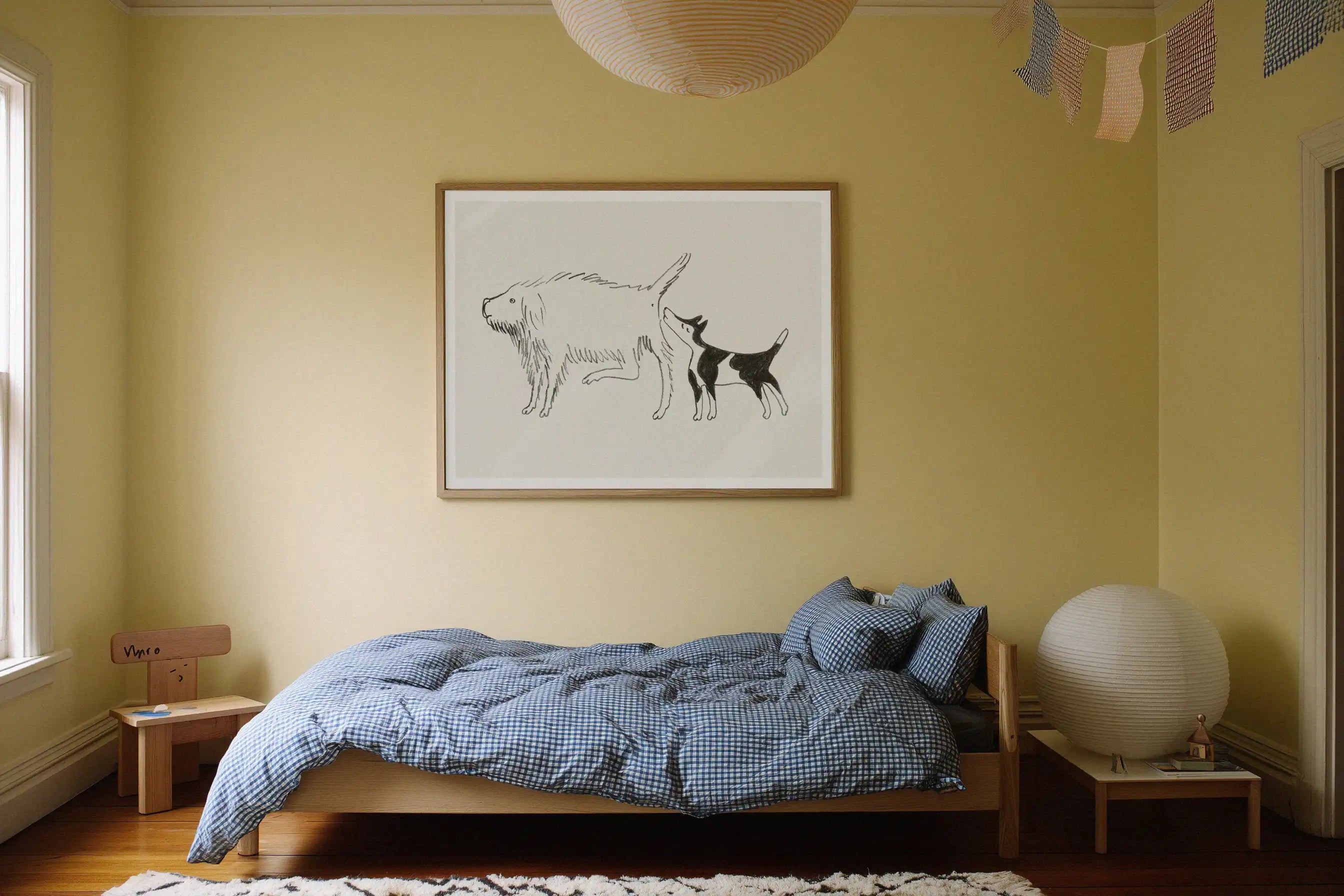 Plakat “Naar enden er god, er alting godt” af Thomas Winding ophaengt i hyggeligt boernevaerelse over seng.