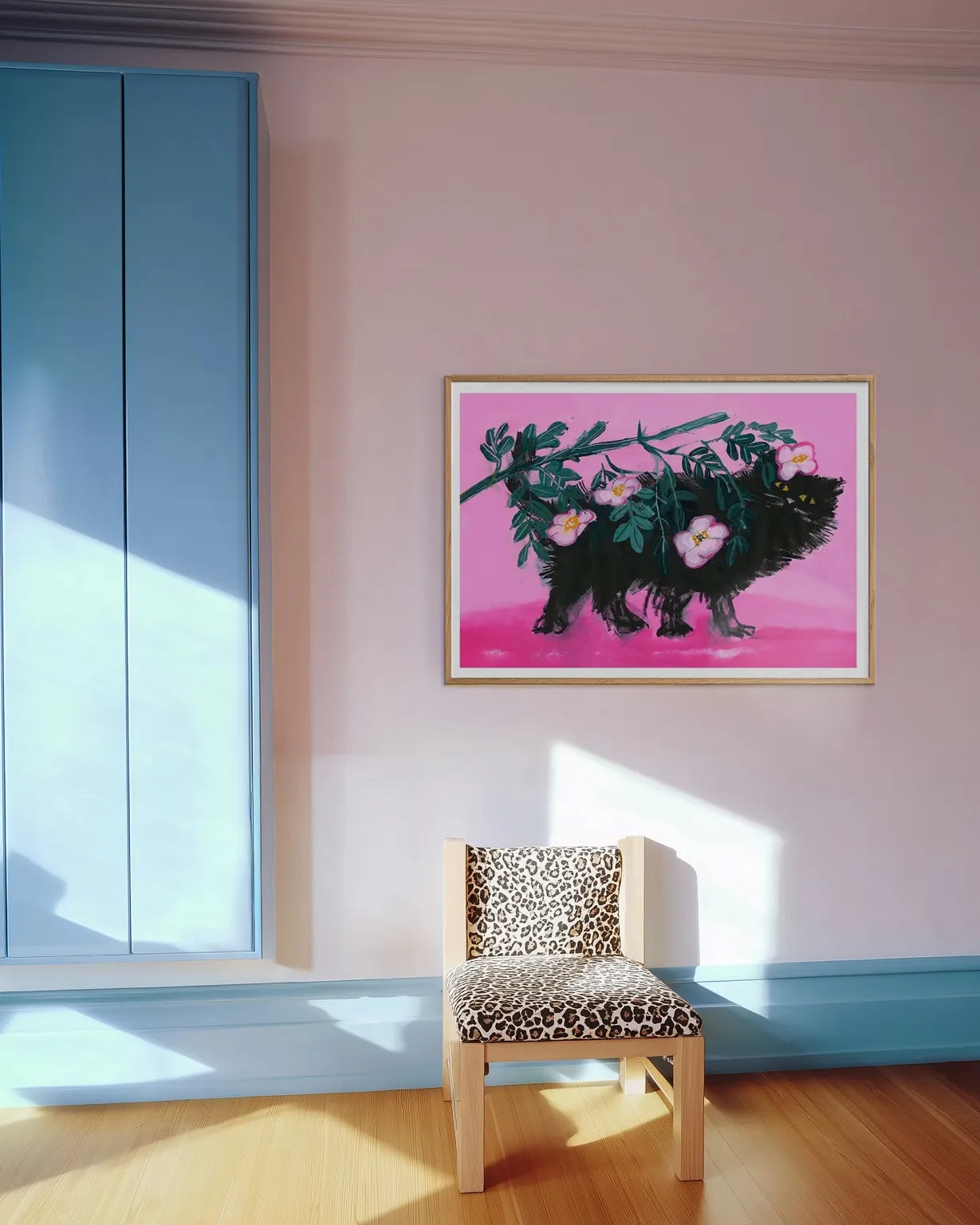 Plakat “Pimme under roserne” af Thomas Winding ophængt i lyst rum med pastelfarver, træstol og rolig indretning.